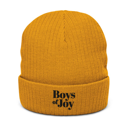 Mustard ribbed beanie, angled front view; cuffed with black ‘Boys of Joy’ embroidery.