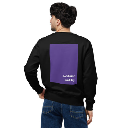 Back view of black eco sweatshirt with large purple rectangle and white ‘No Shame. Just Joy.’ text; model in jeans looking over shoulder.